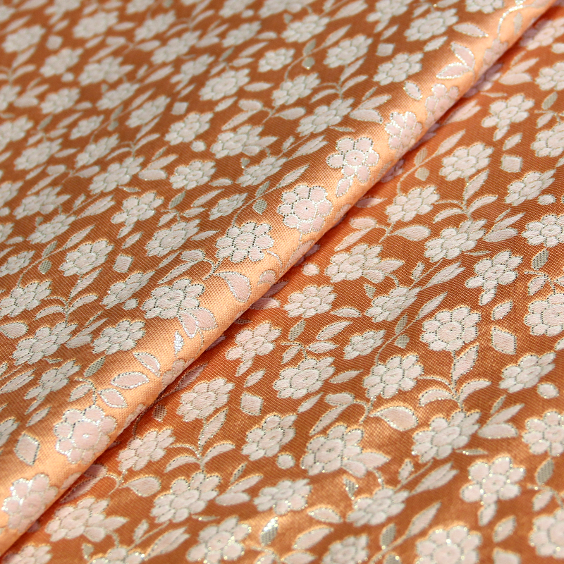 Tissu broché - Petite fleur rose pâle fond saumon
